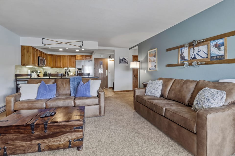Relax in your spacious living area with comfortable leather sofas and rustic mountain decor, perfect for unwinding after your adventures.