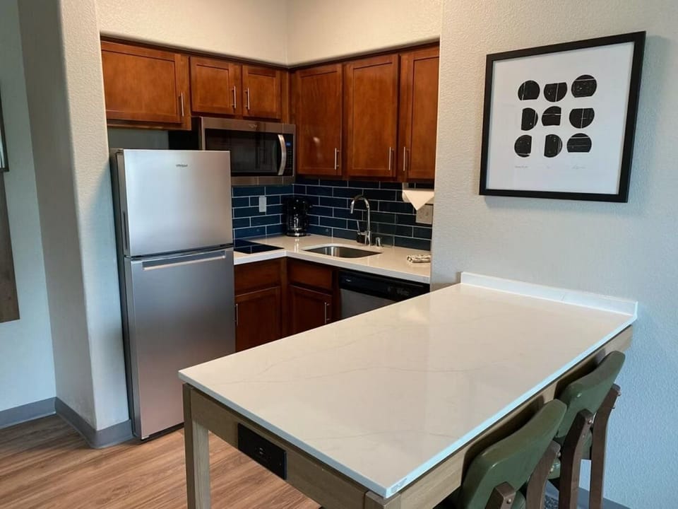 Kitchen with dark wood cabinets, stainless appliances, and a two-seat dining bar