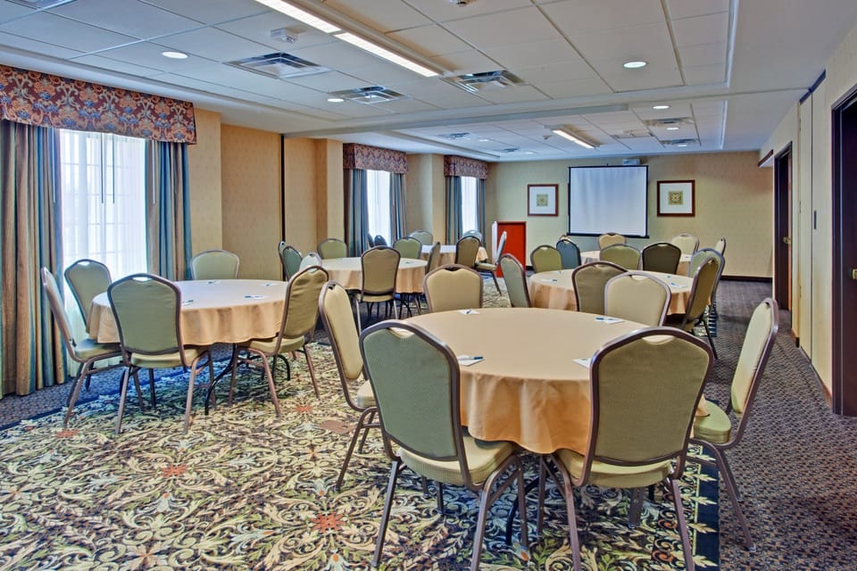 Spacious meeting room with round tables and comfortable chairs.