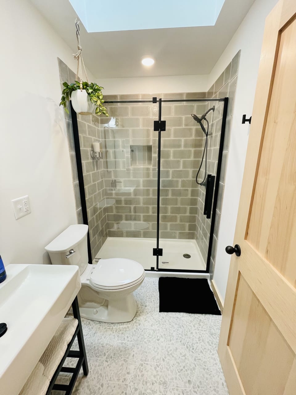 Bathroom shower with a handheld sprayer, body wash and shampoo provided