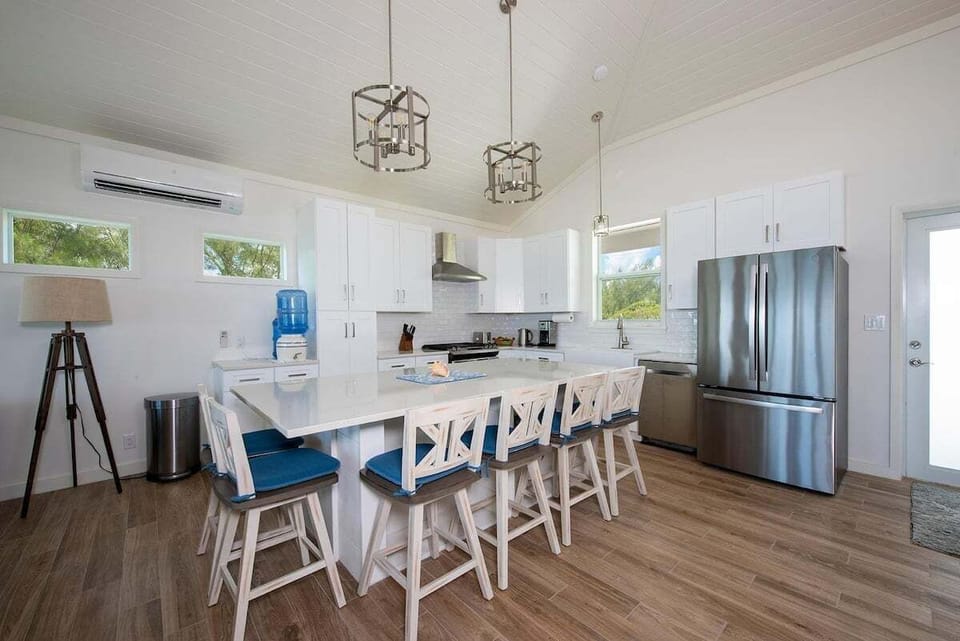 Appliances include a gas range and French-door refrigerator. The large quartz-topped island has seating for 6 and under-counter beverage fridge.