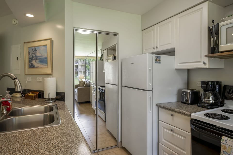 12 cup drip coffee maker, toaster, full size appliances. Washer and dryer behind glass door bifold doors.