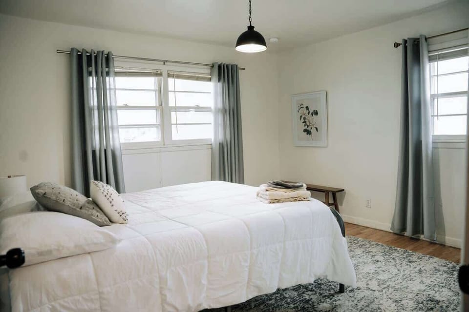 Bright and airy king bedroom with plush white bedding and cozy area rug