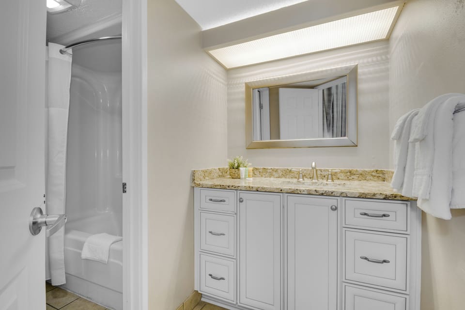 A sophisticated bathroom graces the space, featuring an elegant vanity sink, a combination tub and shower, and a toilet for your comfort and convenience.