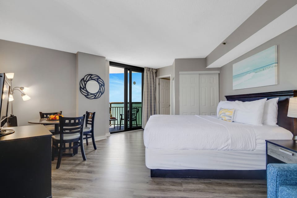This unit boasts a generous 1 King-size bed, complemented by expansive sliding doors that open up to a roomy balcony with a serene view of the ocean.