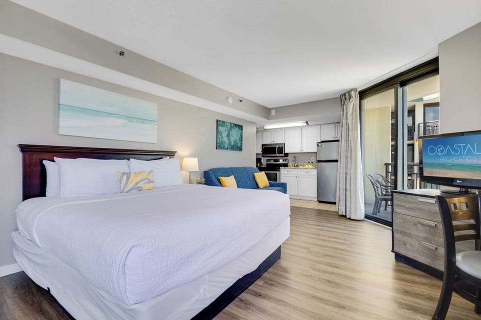 This unit boasts a generous 1 King-size bed, complemented by expansive sliding doors that open up to a roomy balcony with a serene view of the ocean.