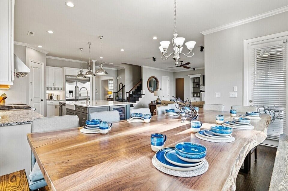 Main Level: Dinning table - Elegant dining area with a rustic wooden table, modern kitchen, and stylish decor. Perfect for family gatherings!