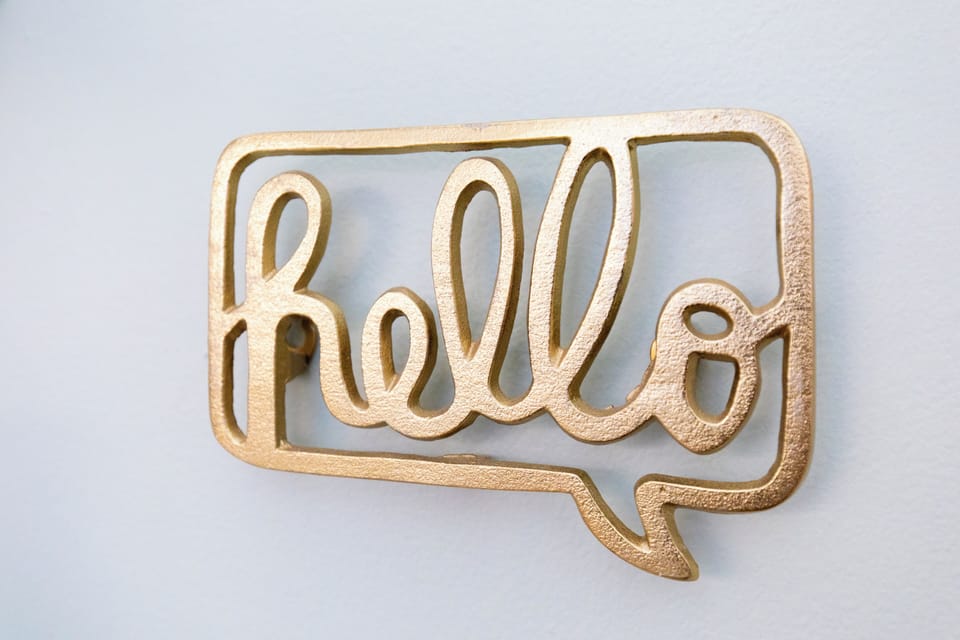 A charming golden 'hello' sign adds a warm, welcoming touch to your space.