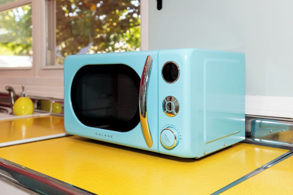 Your retro turquoise microwave adds cheerful charm to this bright kitchen, perfect for quick meals during your getaway.