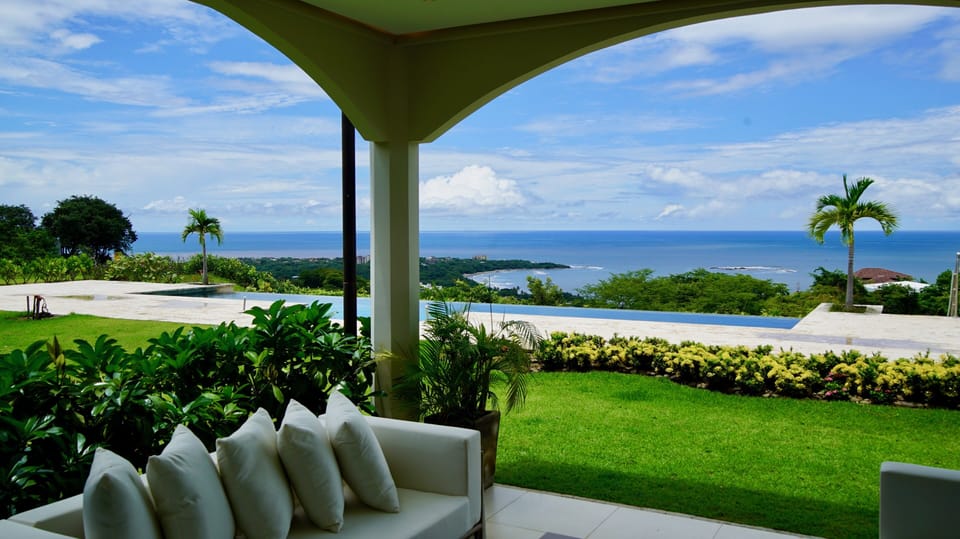 View of pool and ocean from covered patio.