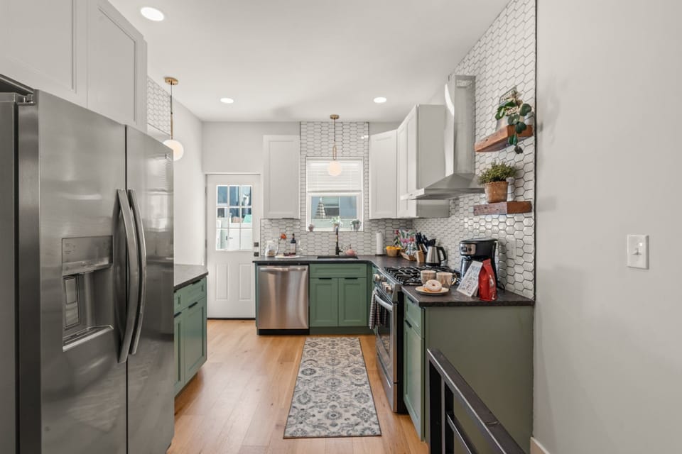 Cook, connect, and unwind in this modern kitchen featuring custom cabinetry, stainless steel appliances, and a bright design.