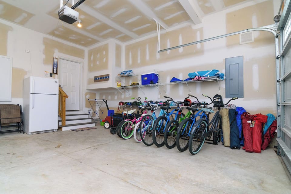 The garage includes bicycles, helmets, a drying rack, and beach and lawn chairs.