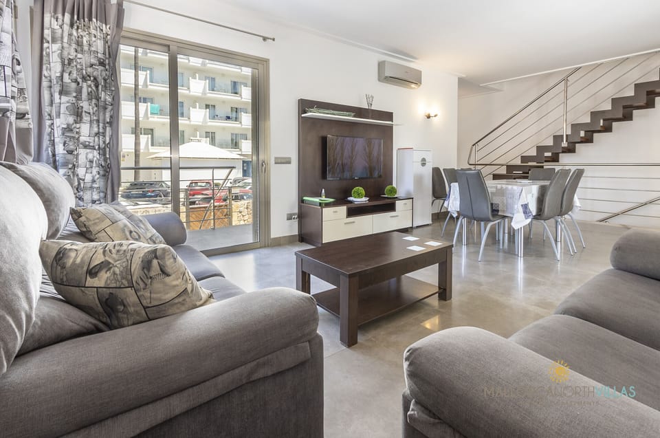 Bright and modern living-dining area in Villa Albufera, featuring comfortable sofas, dining space, terrace access and contemporary design.