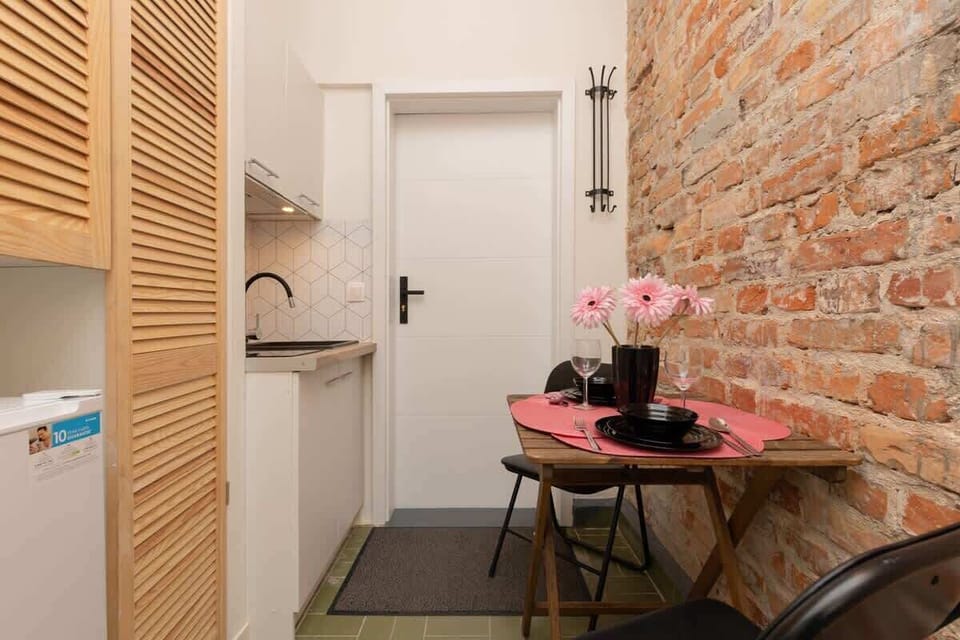 A close-up of the kitchenette, highlighting the wooden accents and exposed brick wall.


