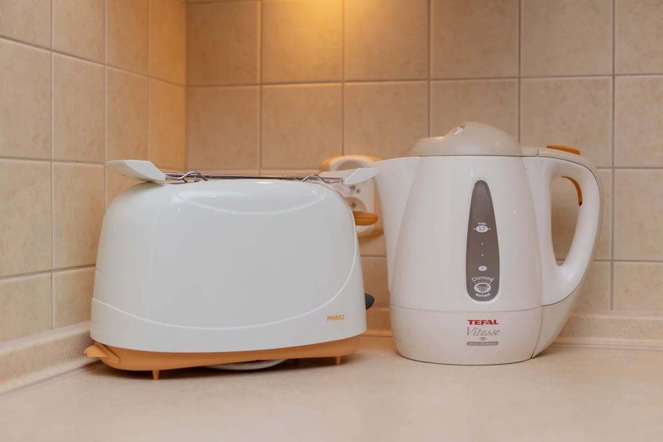 A close-up of a toaster and kettle, showcasing the convenience of the fully equipped kitchen.
