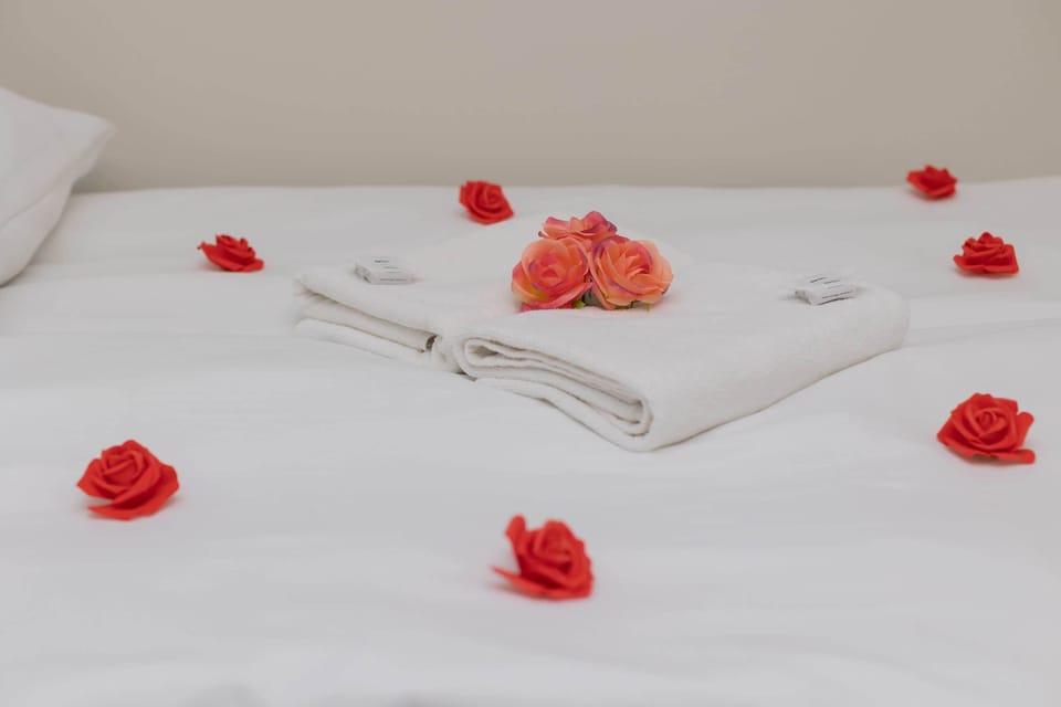 A close-up of the bed adorned with decorative rose petals, providing a romantic and welcoming touch for guests.
