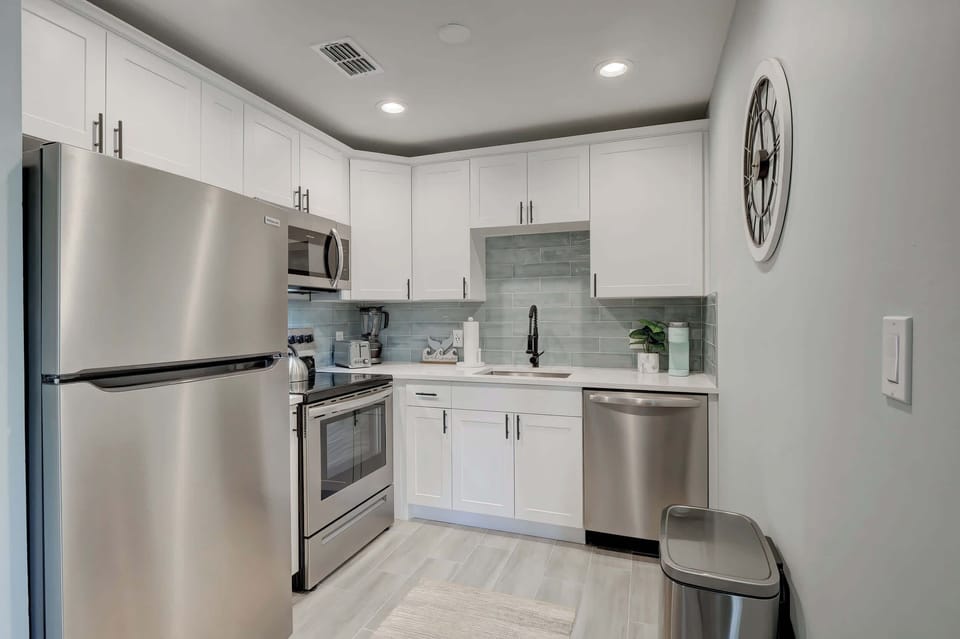 There is a Full Ensemble of Stainless Steel Appliances in the Kitchen and a Gorgeous Tiled Backsplash