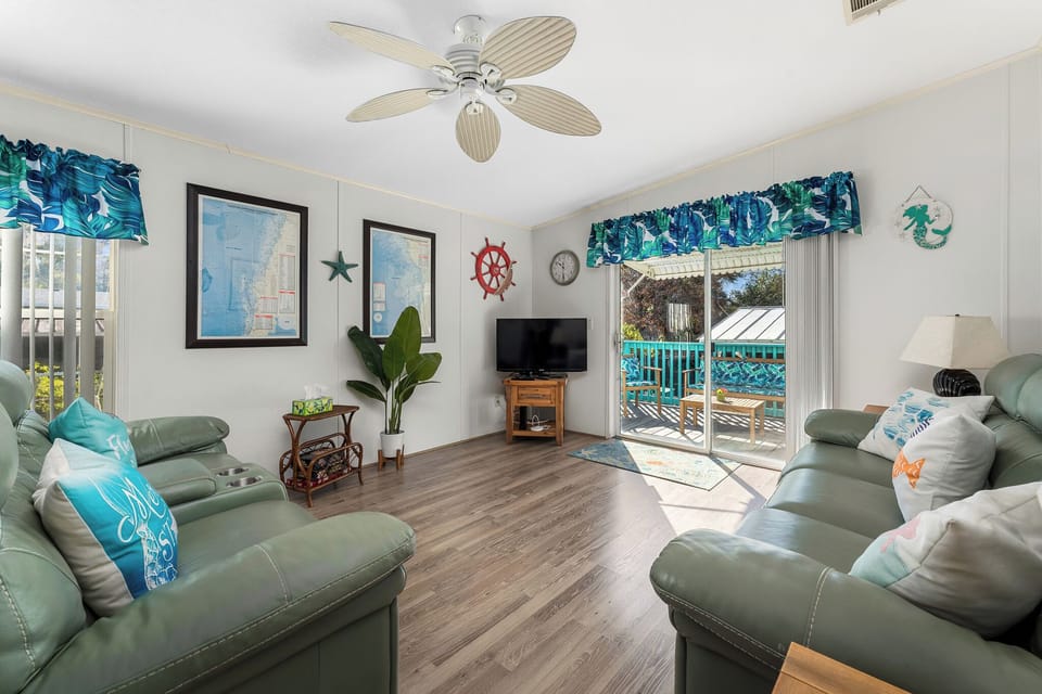 Our sunny Florida room features two leather reclining couches, a TV with Roku device, and a sliding patio door that leads to the deck & back yard.