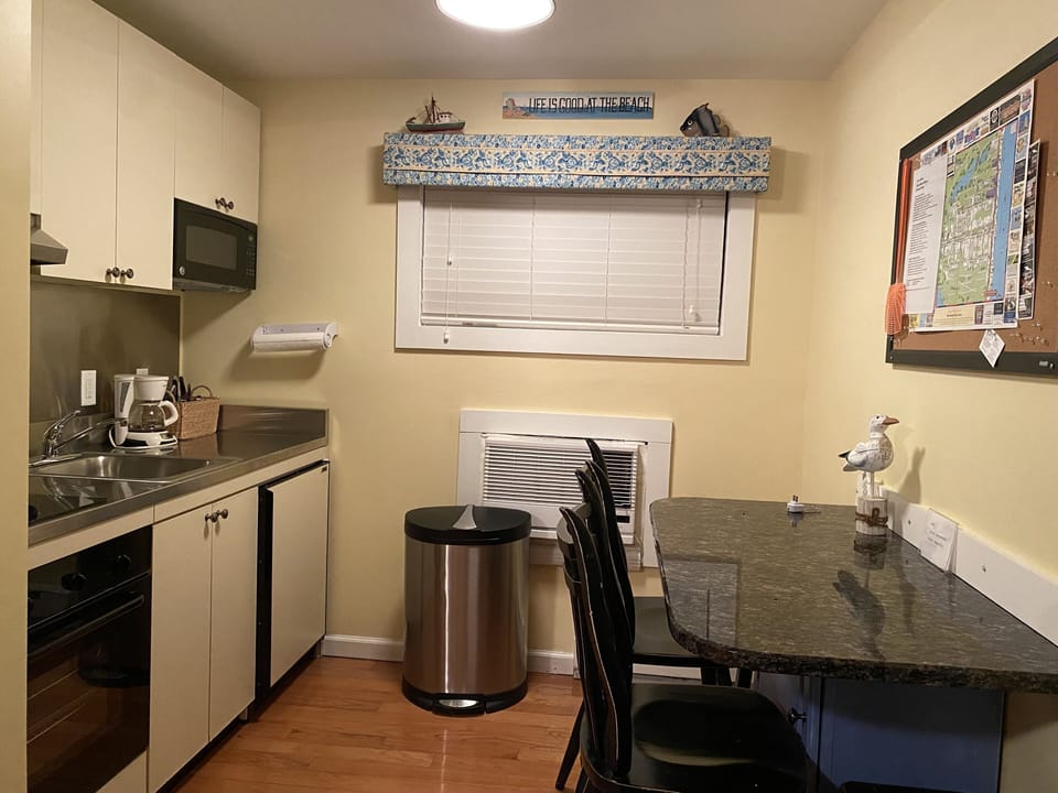 Kitchen with oven, two burner stovetop, microwave, small fridge/freezer, coffee