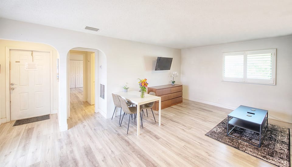 View from entry showing living room, queen pull out sofa, smart TV and dining table.