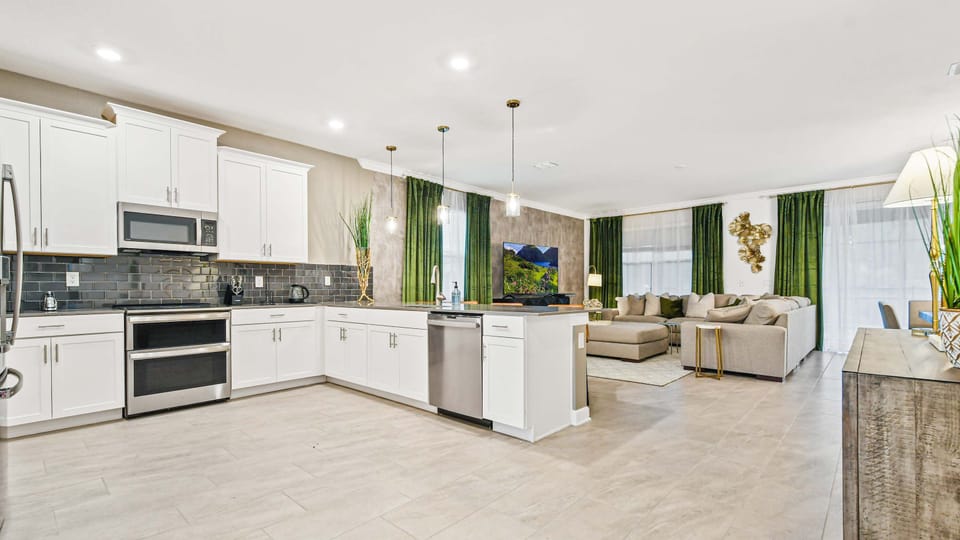 Bright open kitchen with sleek finishes, island seating, and connected living space