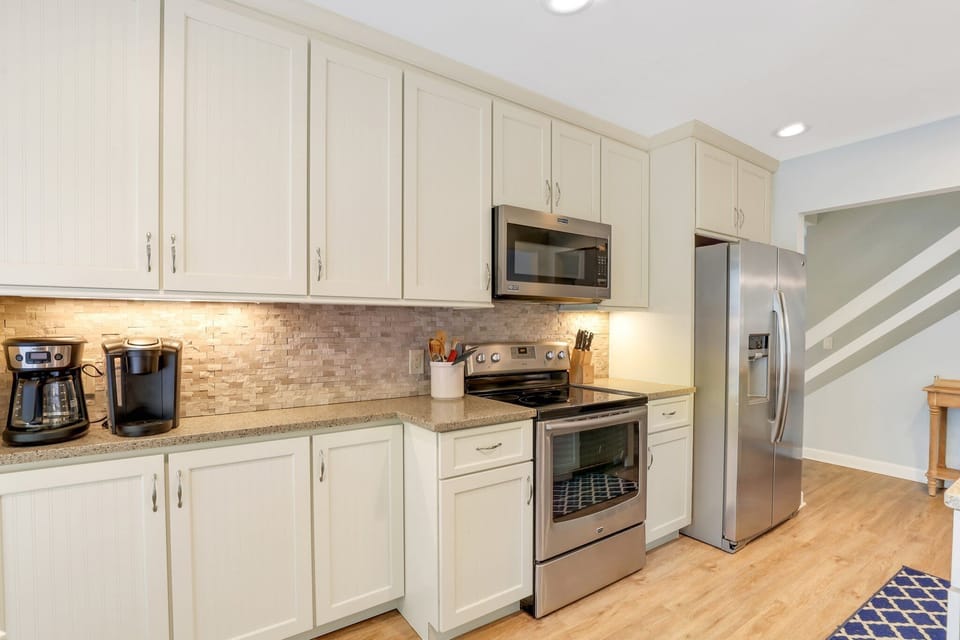 Fully equipped kitchen with stainless steel appliances, ample counter space, and a cozy breakfast nook.