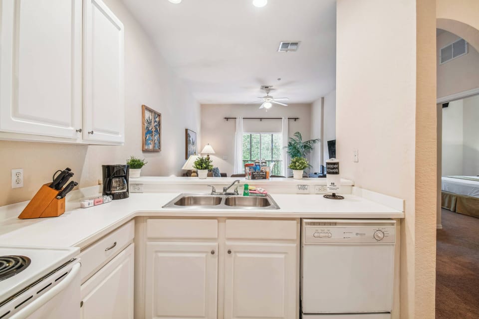 Welcome to this beautifully designed kitchen with bright white cabinetry and sleek countertops, perfect for your culinary adventures. The natural light from the living area adds warmth and creates an inviting atmosphere for you.