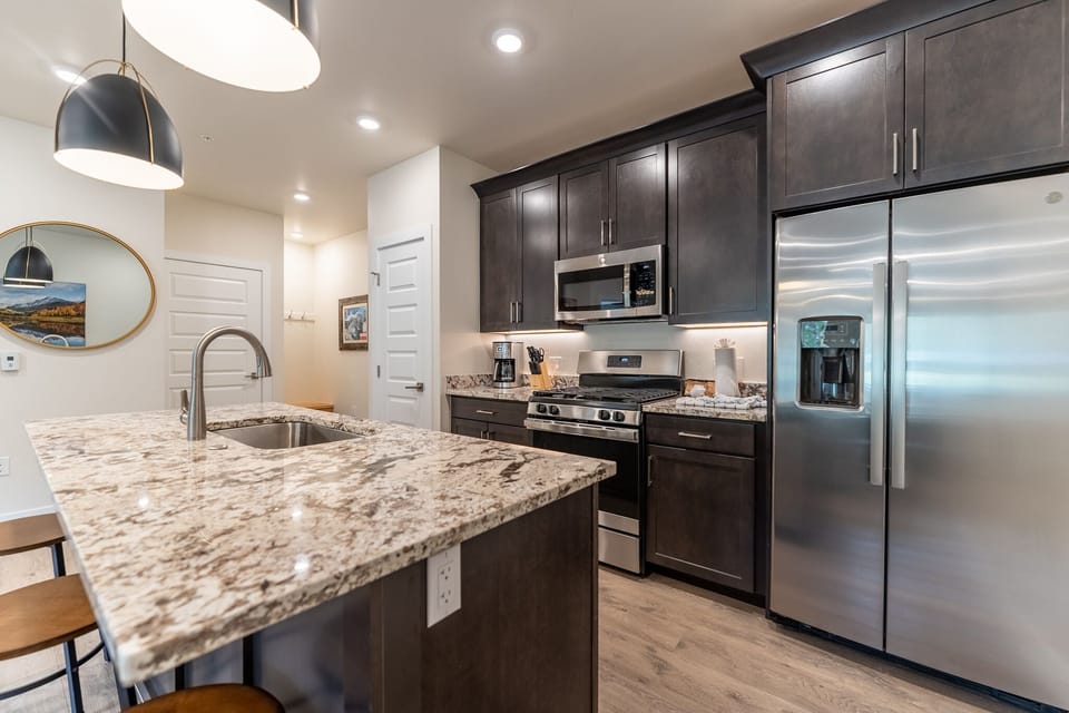 Your gourmet kitchen features granite counters, stainless appliances, and stylish pendant lighting for memorable cooking experiences.