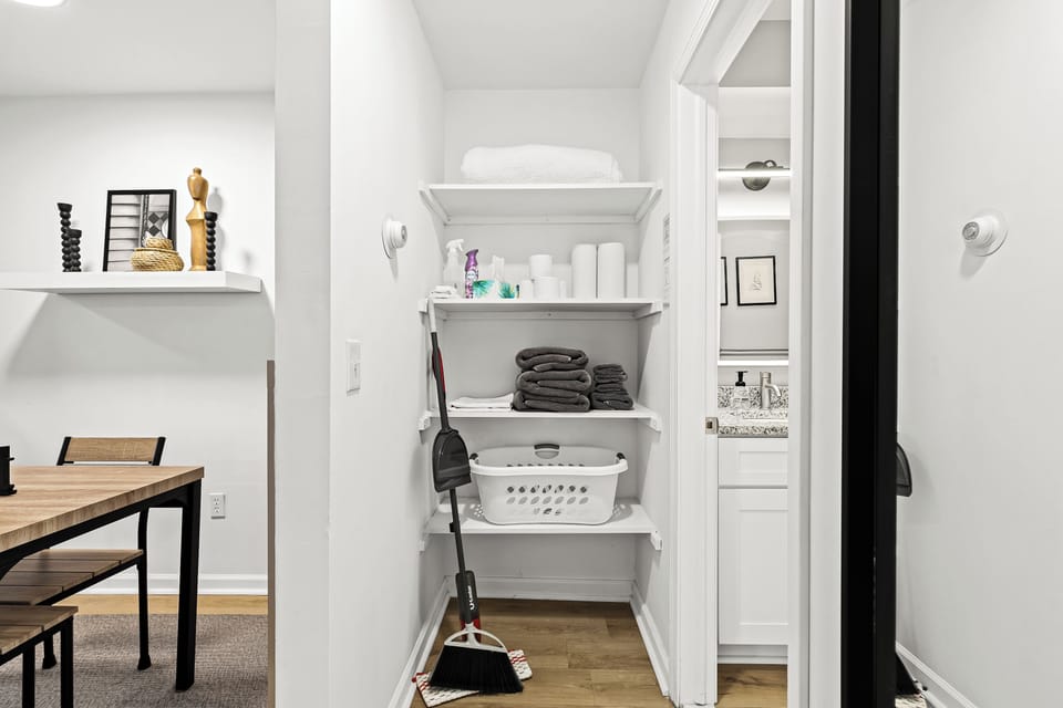 A closet that is used to store cleaning supplies and laundry.