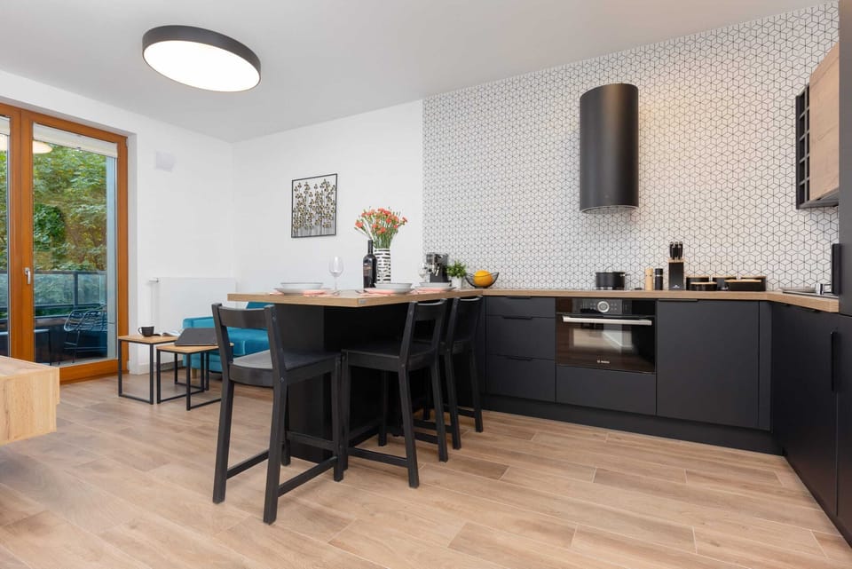 Lounge area and fully equipped kitchenette with induction cooktop and dining area.