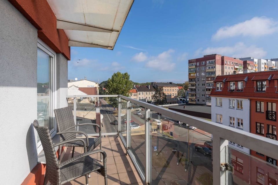 Spacious balcony with outdoor seating offering picturesque city views.
