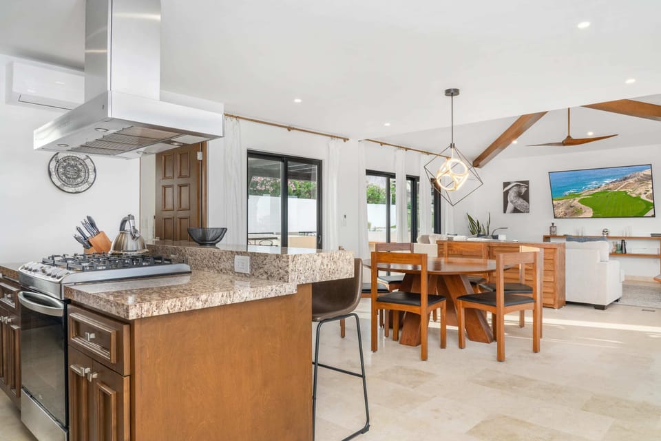 Open floor plan with glass doors that open to ocean views