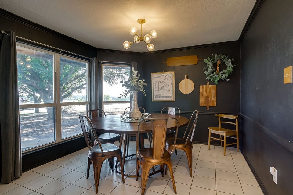 Dining with a view — bright windows frame the pool and firepit while everyone lingers over dinner.