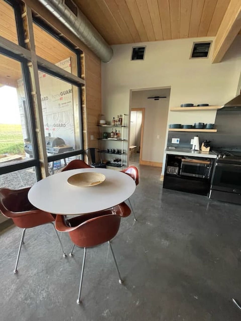 Bunk House dining table with barn door doorway the the west side of the house- west primary bedroom, west bathroom and the bunk room.