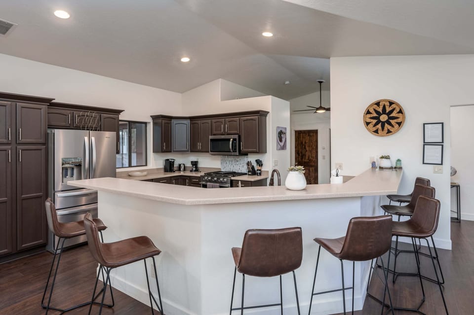Gather, cook, and connect in the spacious open concept kitchen, featuring a large breakfast bar with seating for the whole group and plenty of room to prepare meals together.
