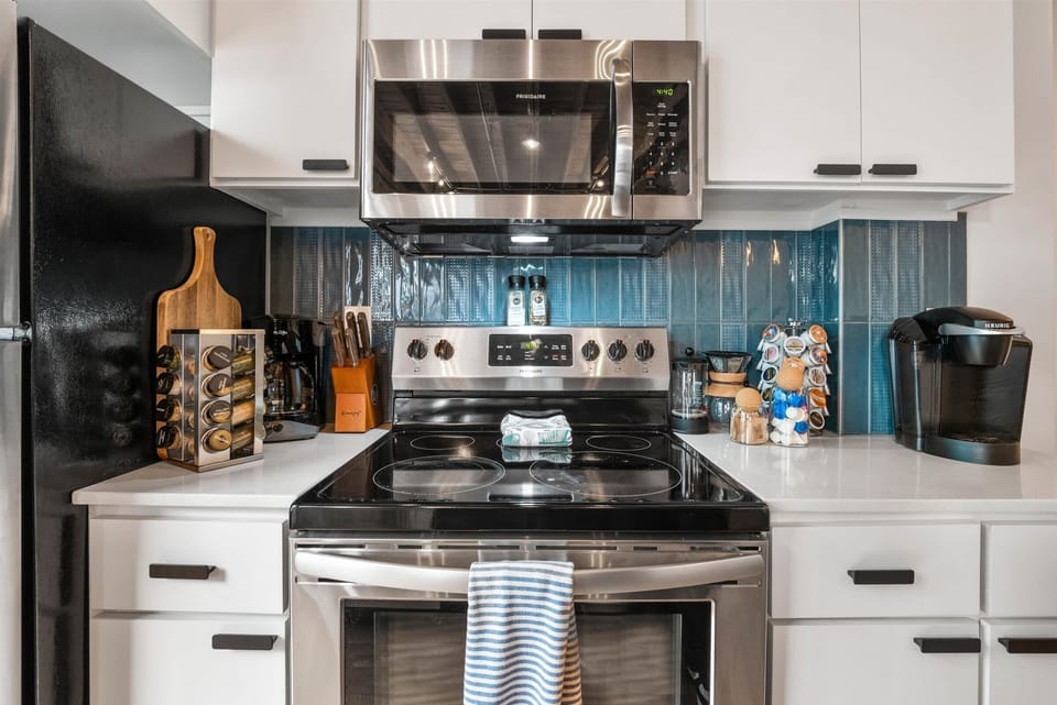 Modern full kitchen with stainless steel appliances, granite counters, coffee bar and island seating in Downtown Kansas City