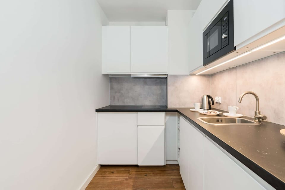 Modern kitchen corner featuring sleek, high-end appliances and a spacious countertop for preparing meals in comfort.
