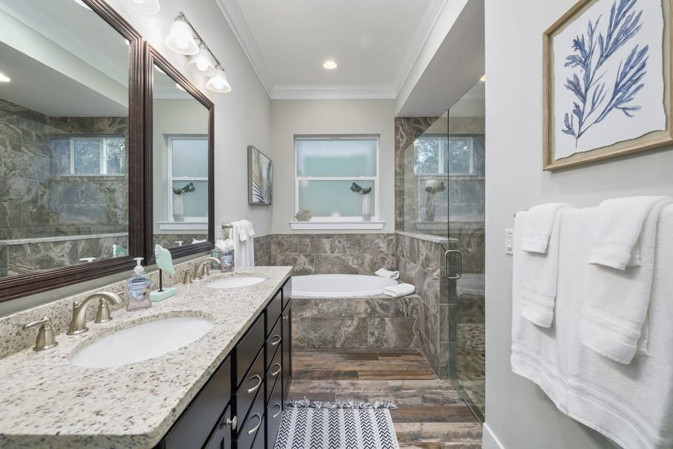 Primary ensuite bathroom with double vainity, walk-in shower and bathtub