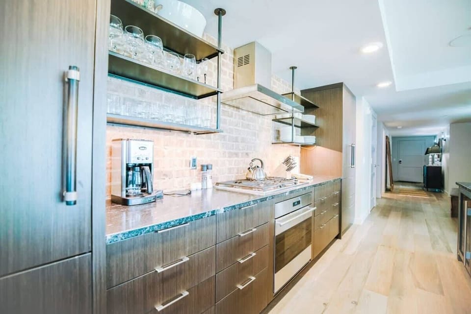 From the stone countertops to the top-of-the-line, stainless steel appliances and large island with pendant lighting, this kitchen has style in spades. It is also full stocked with everything from a tea kettle and toaster to elegant stemware.