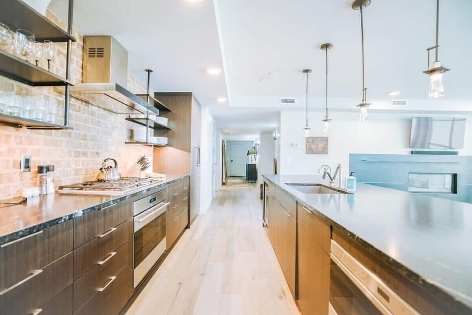 From the stone countertops to the top-of-the-line, stainless steel appliances and large island with pendant lighting, this kitchen has style in spades. It is also full stocked with everything from a tea kettle and toaster to elegant stemware.