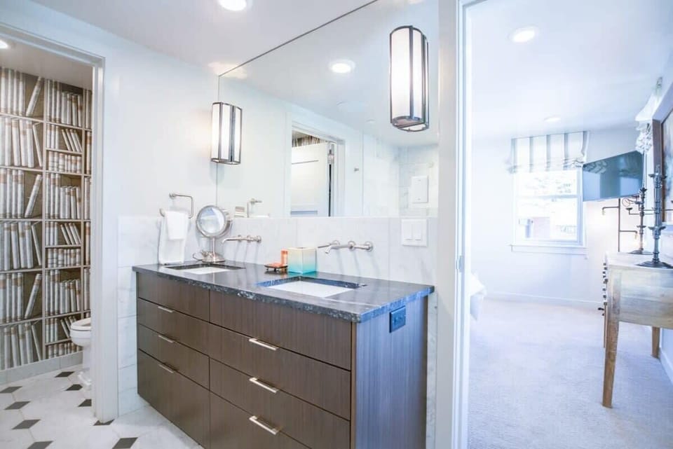 The en suite master bathroom is fully-tiled and features a double-sink vanity, a walk-in shower with a glass surround, a tiled bathtub and separate toilet closet.