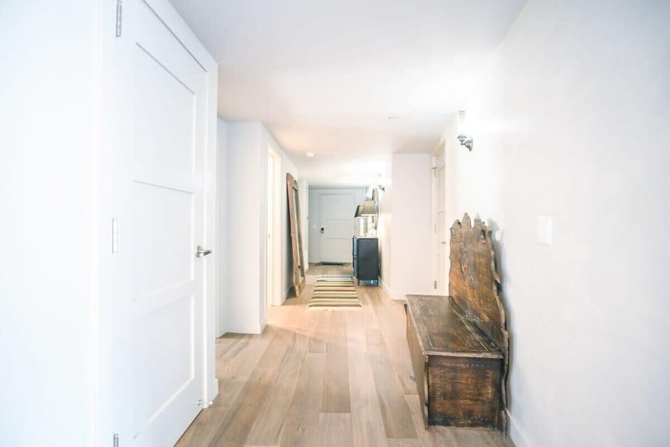 This hallway leads from the open living space to the entrance and additional bedrooms.