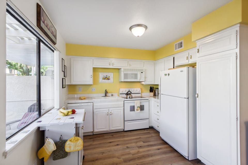 Kitchen with dishwasher, microwave, range, fridge, and coffee maker