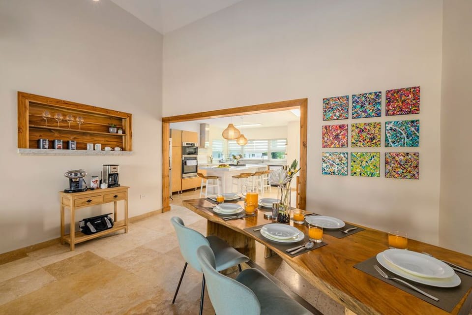 Gather around this beautiful dining table where morning coffee and shared meals become cherished memories. Bright, inviting spaces flow seamlessly into the modern kitchen beyond.