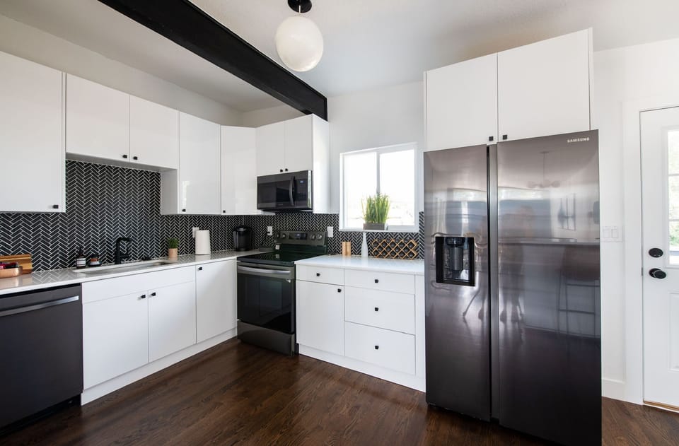 Fully equipped chef's kitchen with stainless appliances and quartz counters.