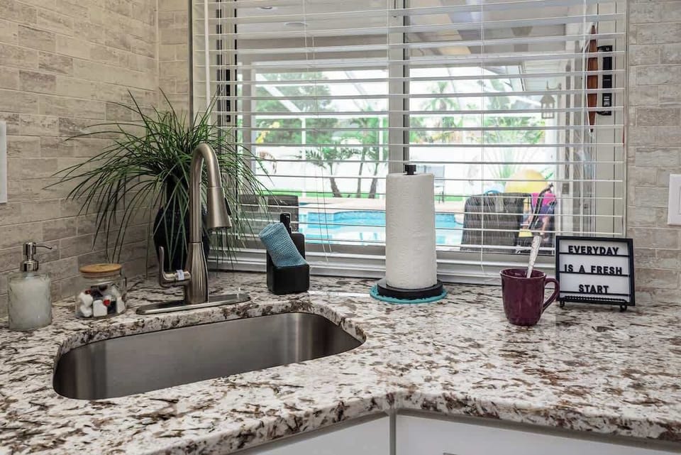 Our kitchen features a modern sink that not only adds to the aesthetic appeal but also enhances functionality. Positioned to offer a view of the pool, it brings in natural light, making dishwashing a more pleasant experience