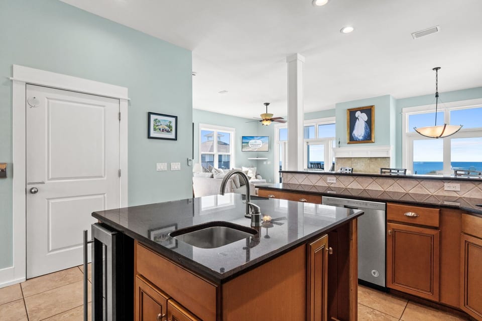 Your gourmet kitchen features granite counters and ocean views, perfect for preparing meals while watching waves roll in.