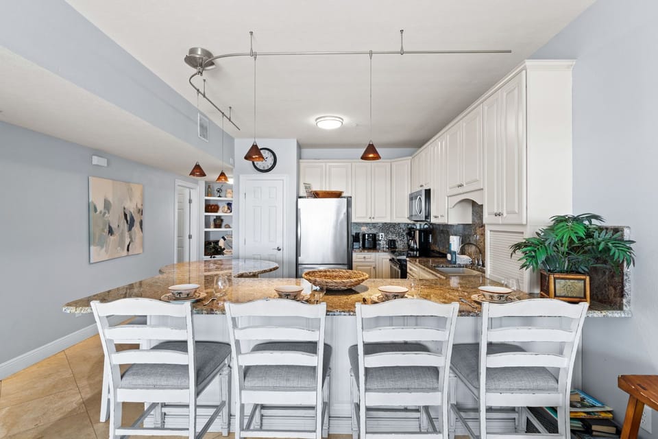 Your spacious kitchen features granite counters, white cabinetry, and comfortable bar seating where you'll enjoy morning coffee and casual meals.