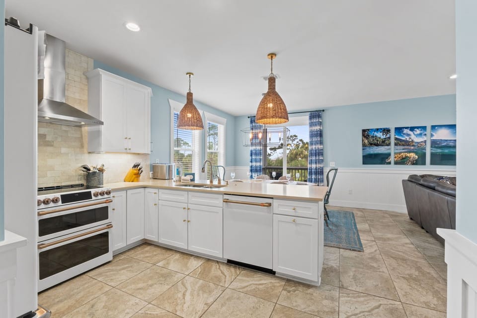 Step into your bright, open-concept kitchen where coastal breezes meet modern comfort. Cook with stainless steel appliances while natural light pours through generous windows, framing serene lake views.