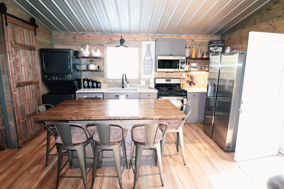 Fully stocked kitchen with spices, paper plates, pots and pans and baking items.